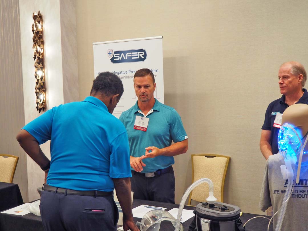 Exhibitor and attendee talking at booth | NAEFO Annual Conference